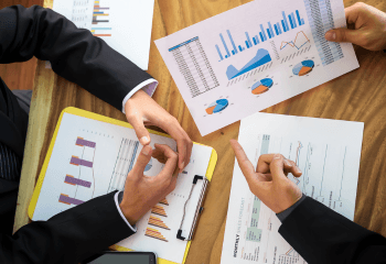 Business Meeting Over Financial Graphs